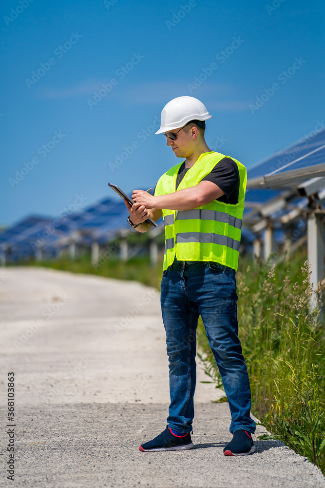 工程师正在检查太阳能发电厂安装的太阳能电池板。