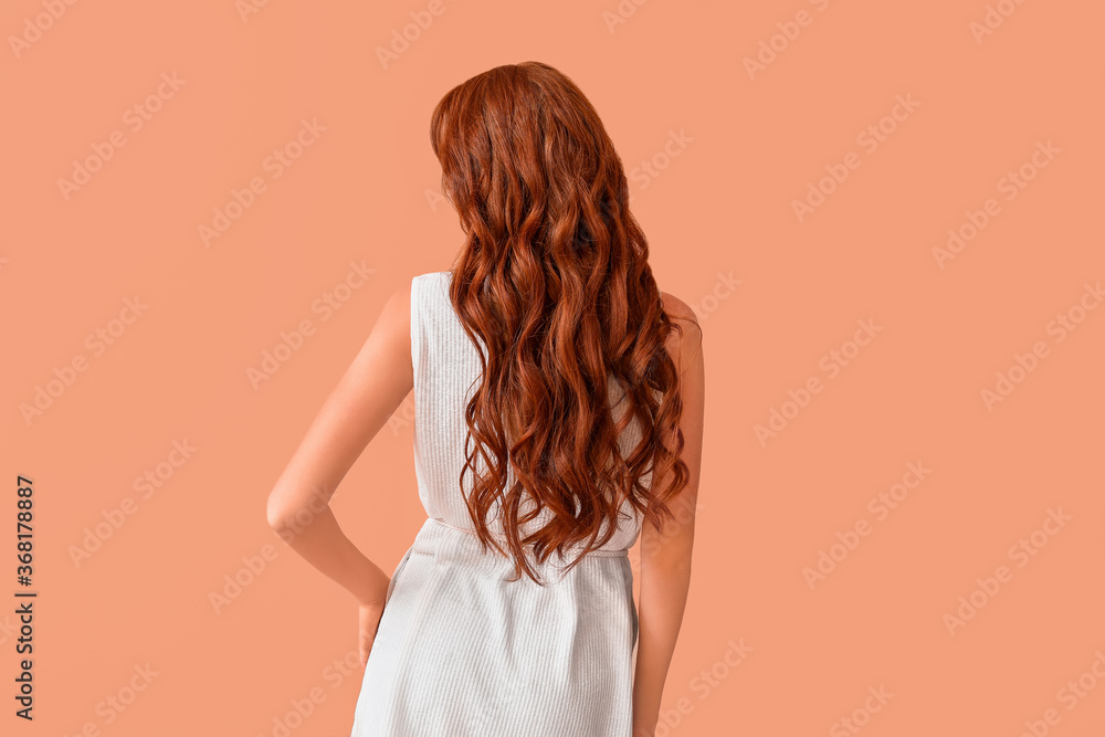 美丽的年轻红发女人，彩色背景，背面视图
