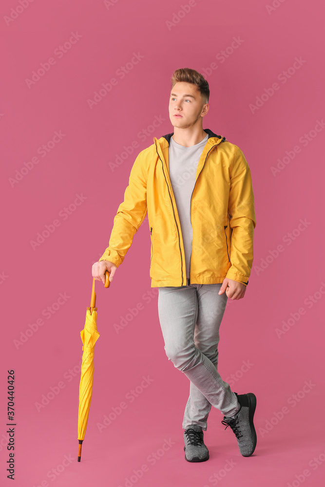 彩色背景带伞的年轻人