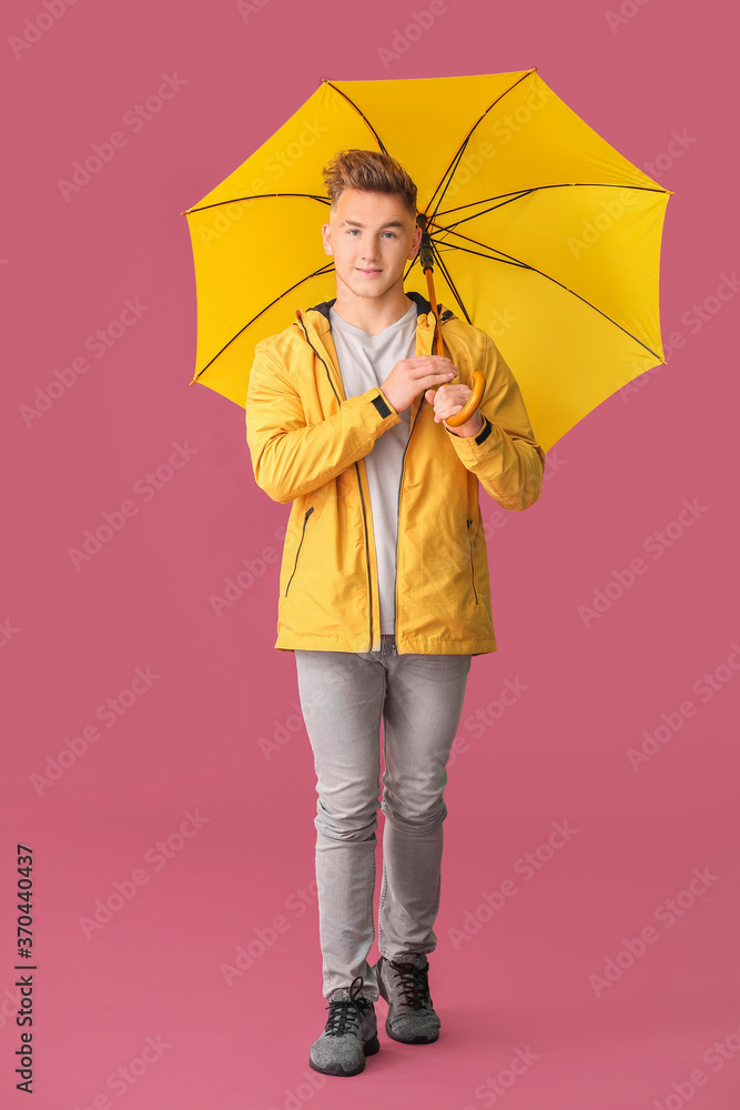 彩色背景带伞的年轻人