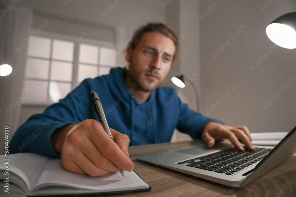 年轻人在家使用笔记本电脑进行在线学习