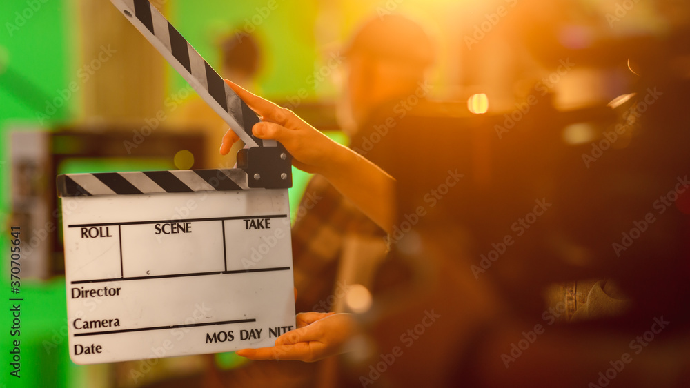 电影制片厂片场特写镜头年轻的摄像助理拿着空的挡板。背景
