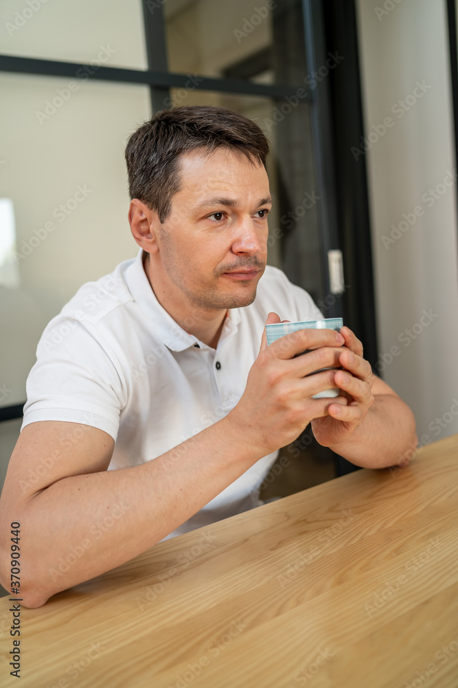 英俊的男人在客厅喝茶。在家休息。
