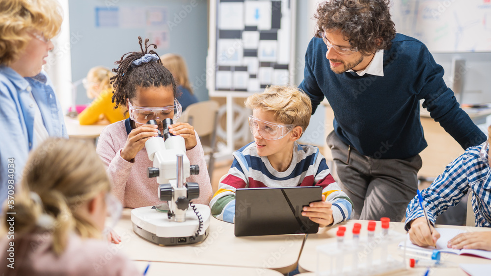 小学科学课堂：可爱的小女孩在显微镜下看，男孩用数字桌子