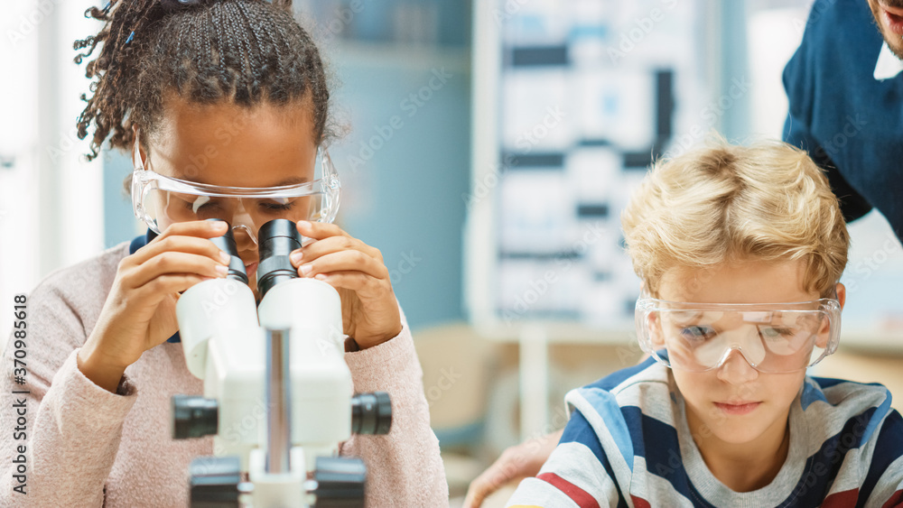 小学科学课堂：可爱的小女孩在显微镜下看，男孩用数字桌子