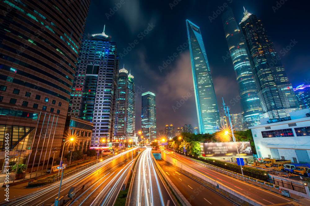 中国上海陆家嘴商业区摩天大楼的景观，夜间街道上车流如织。As
