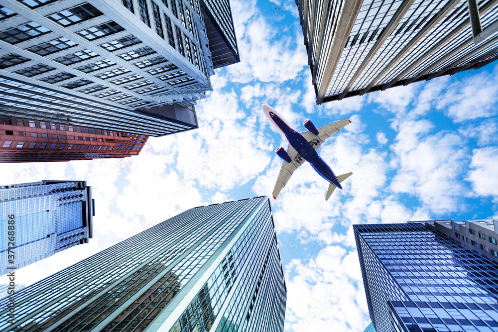 飞机飞越纽约摩天大楼之间的天空