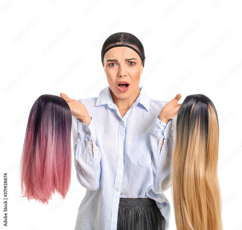 Stressed young woman with different wigs on white background