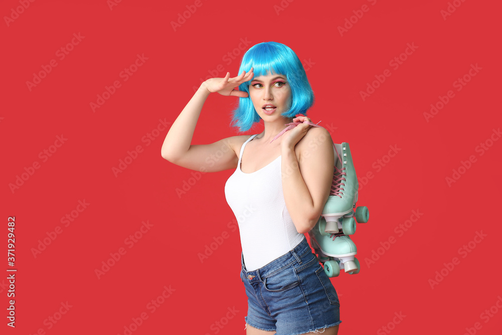 Beautiful young woman in wig and with roller skates on color background