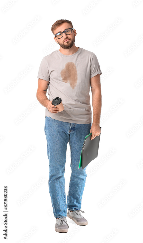 Stressed young businessman with coffee stains on his t-shirt on white background
