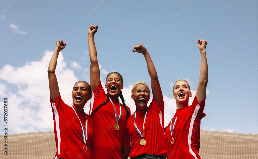 Professional female soccer players celebrating a victory
