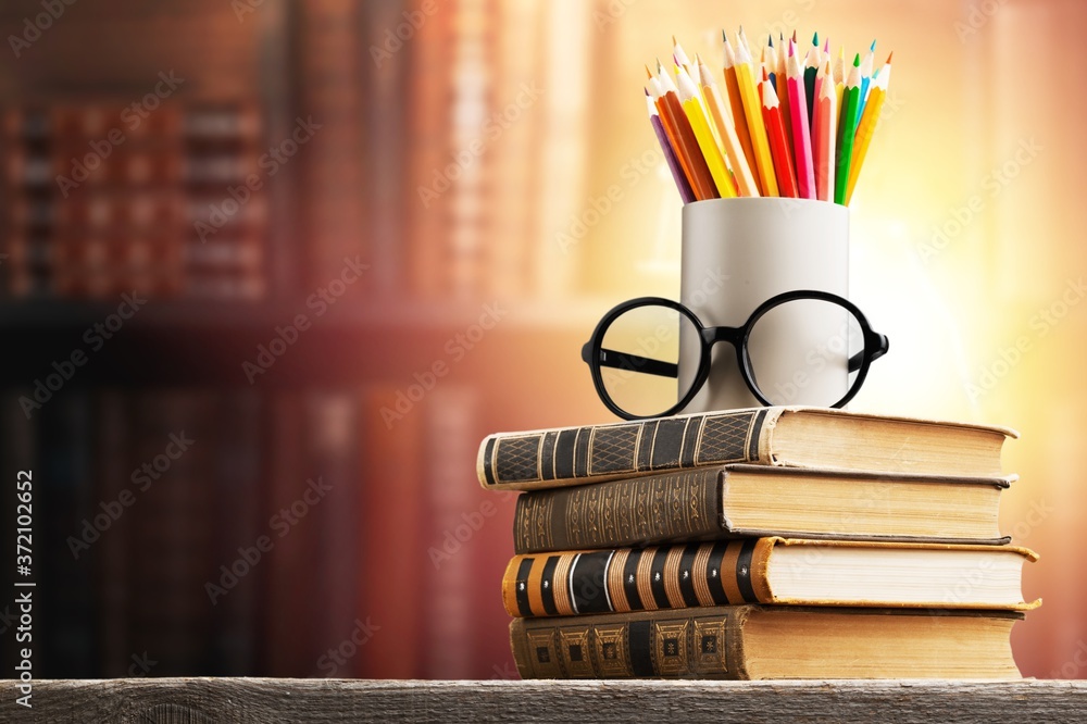 一堆旧书、眼镜和铅笔，教育和学习