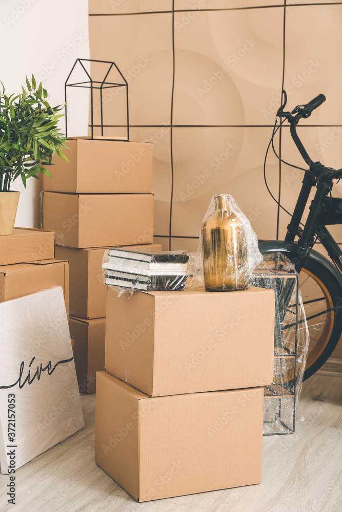 搬家当天新公寓里有纸板箱，里面有物品和自行车