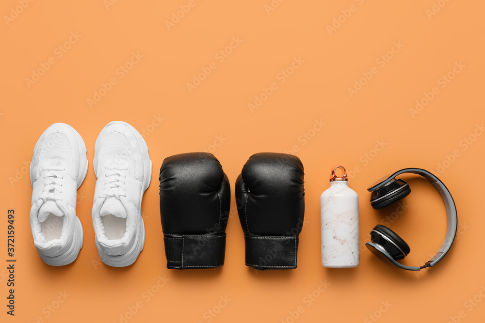 拳击手套配鞋、水瓶和彩色背景耳机