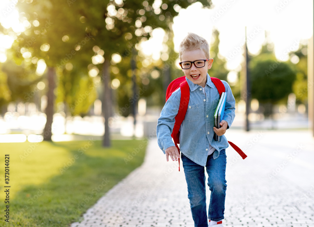 快乐的小学生在公园里跑步。