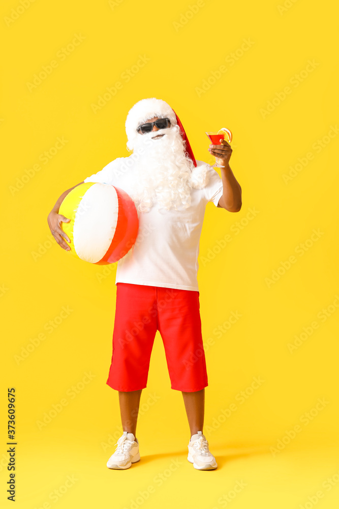非洲裔美国圣诞老人，背景为沙滩球和鸡尾酒