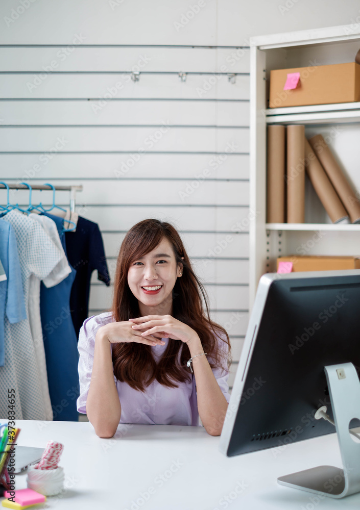 描绘年轻的亚洲女性小企业主，在线营销，通过in在线销售服装