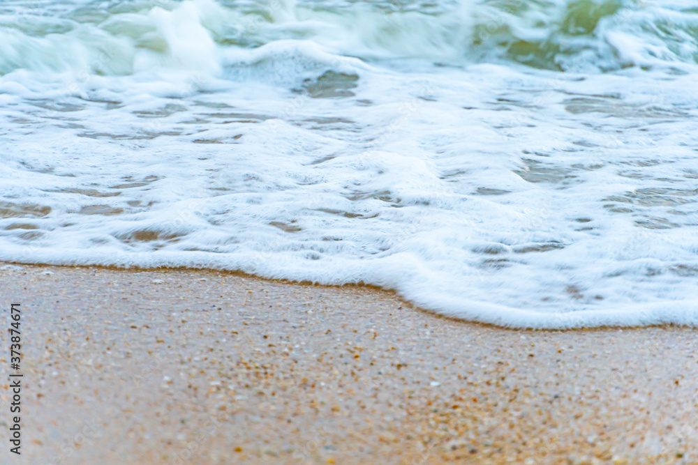 沙滩上的海浪泡泡特写。度假度假和自然感觉的背景。