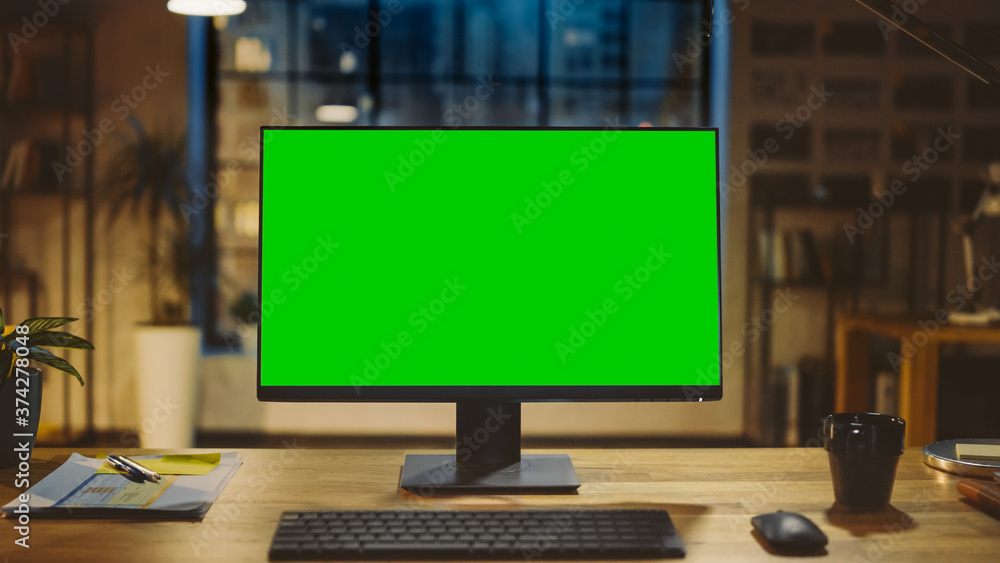 现代创意办公室木桌上立着实体绿屏台式电脑