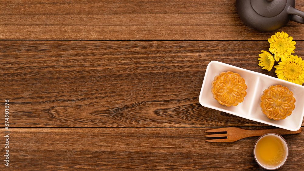 中秋节月饼，美味漂亮的新鲜月饼，放在深色木巴上的盘子里