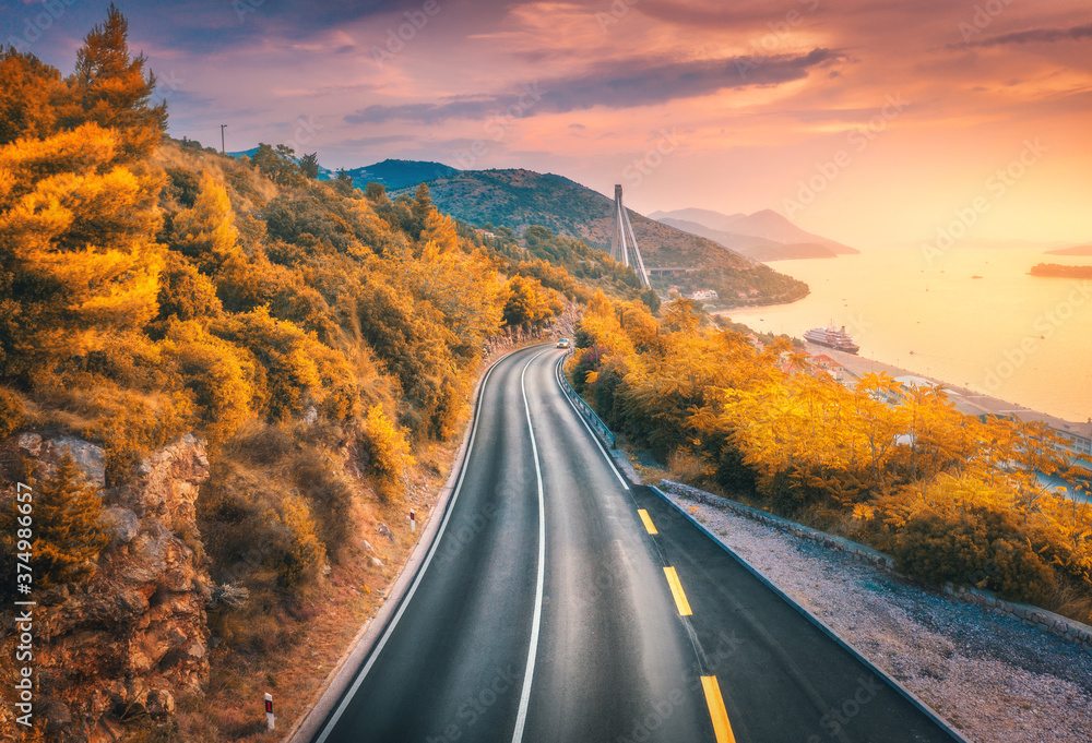 秋天五颜六色的日落下，山路和美丽的橙色森林的鸟瞰图。克罗地亚杜布罗夫尼克