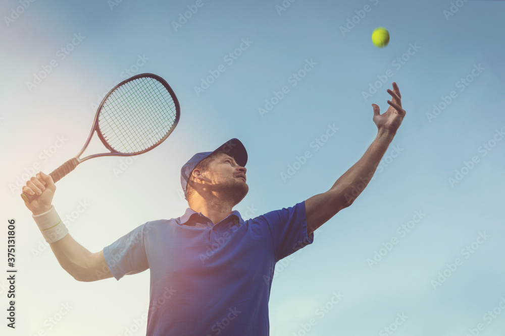 活跃的年轻人在户外打网球。在蓝天下发球