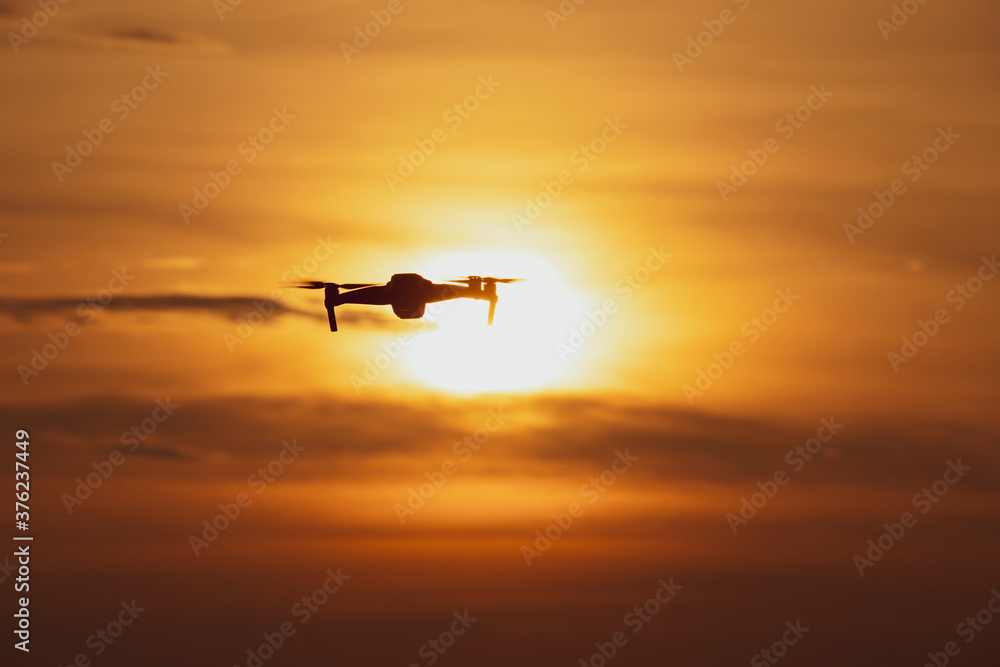 无人机在美丽的日落中飞行的剪影，日落天空中的无人机，无人机拍照