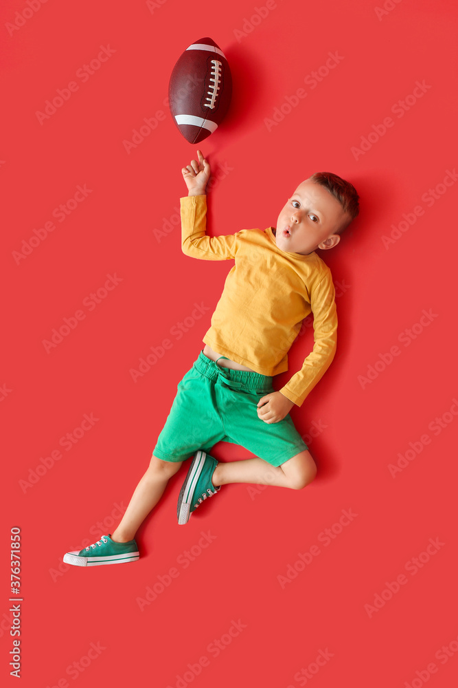彩色背景带橄榄球的小男孩，俯视图