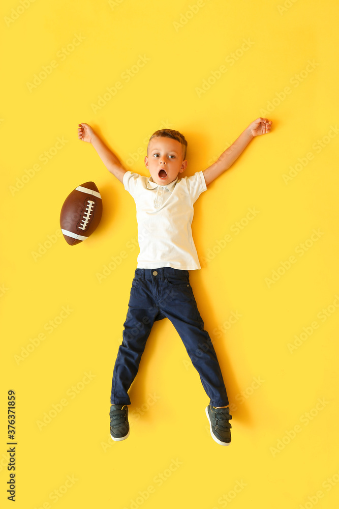 彩色背景带橄榄球的小男孩，俯视图