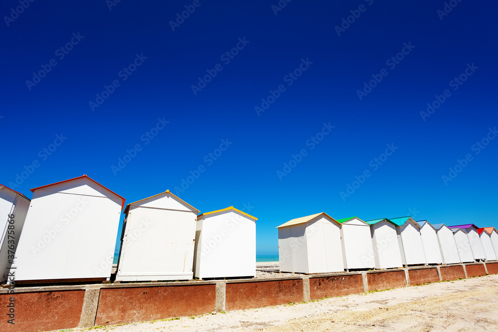 Many wooden cabins and kiosks on Etretat, France over sea with blue sky