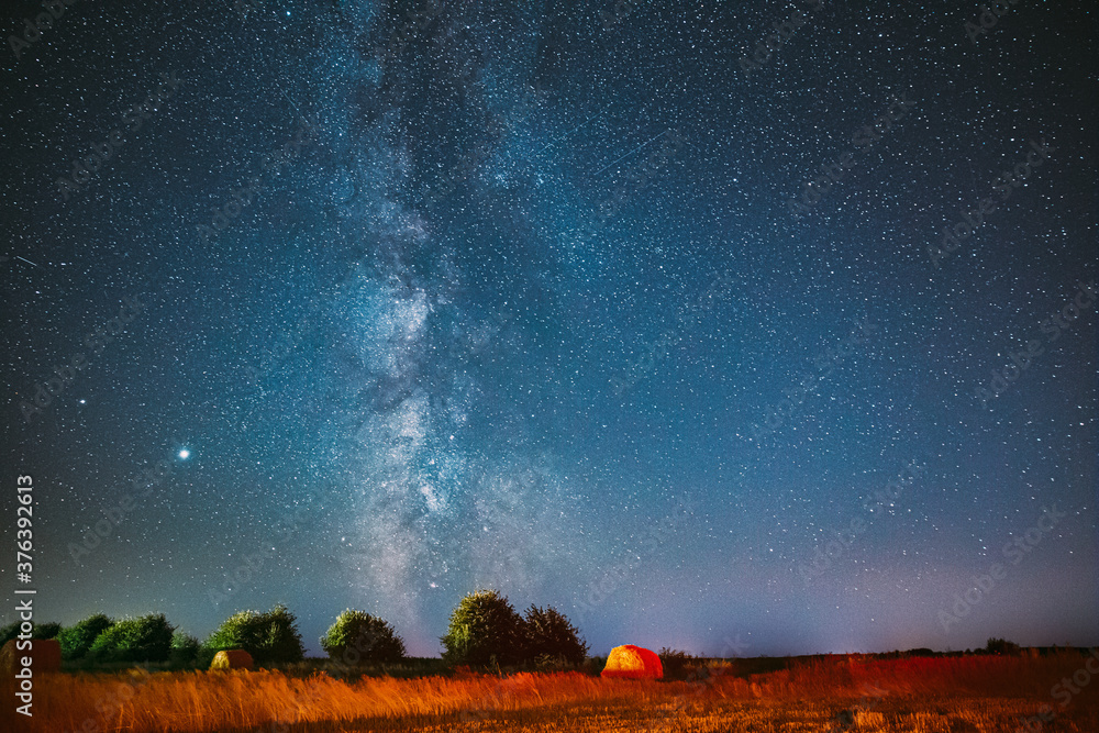 夜晚的银河系。夏季农田干草堆上方的星空。上方的夜星