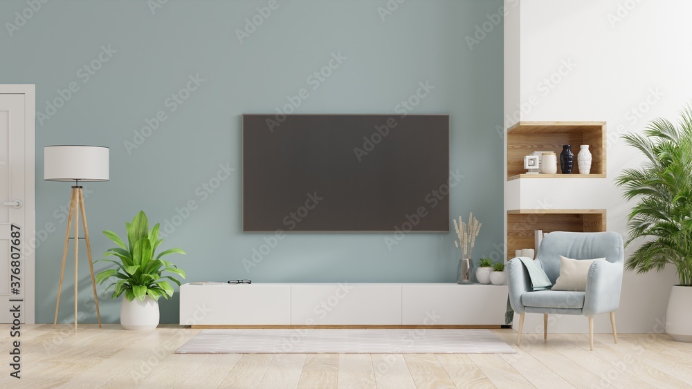 现代客厅橱柜上的电视，明亮的客厅内部，蓝色墙壁上有扶手椅