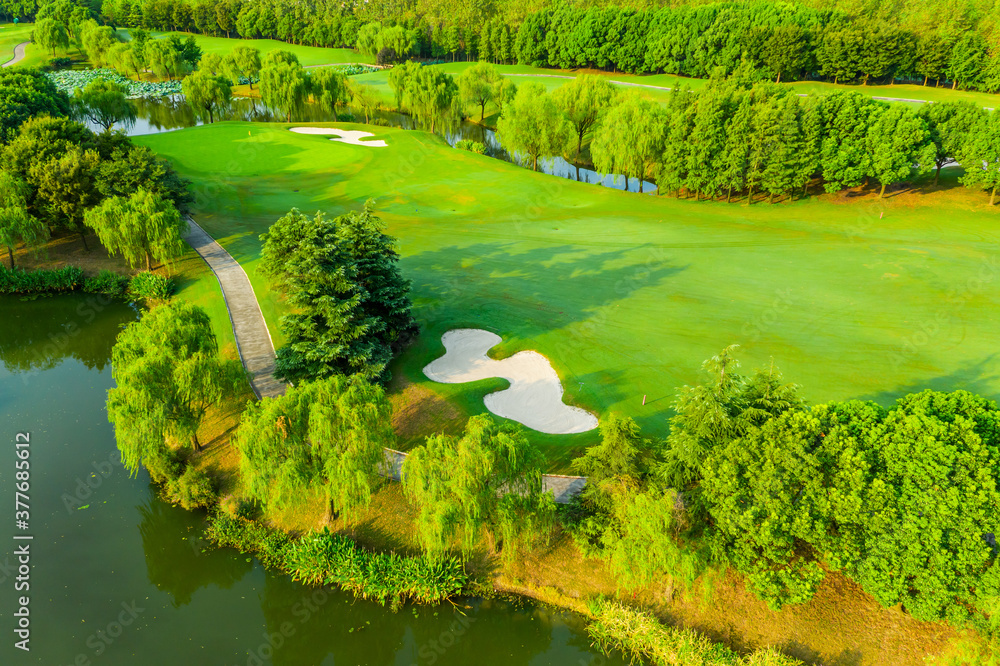 高尔夫球场上绿草如茵和绿树的鸟瞰图。