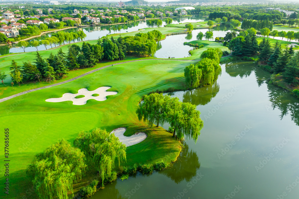 高尔夫球场上绿草如茵和绿树的鸟瞰图。