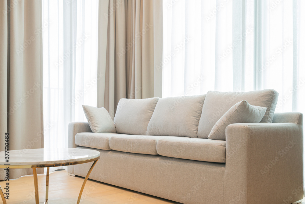 近距离浅米色织物沙发，大窗户的室内背景带来温暖舒适的晨光