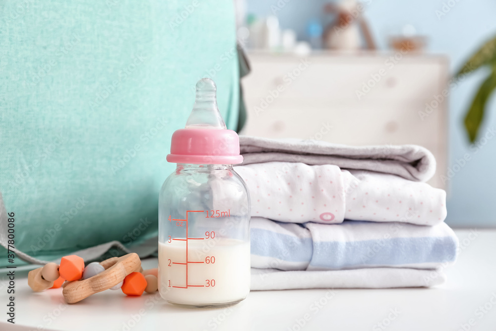 房间里桌子上放着衣服和袋子的婴儿奶瓶