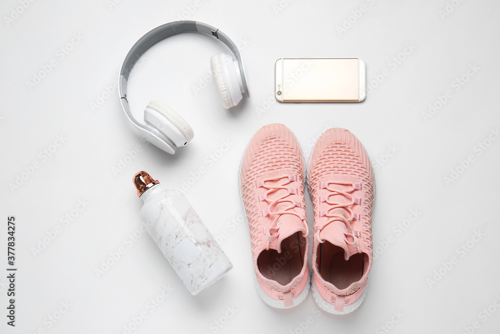 白底运动鞋、一瓶水、手机和耳机