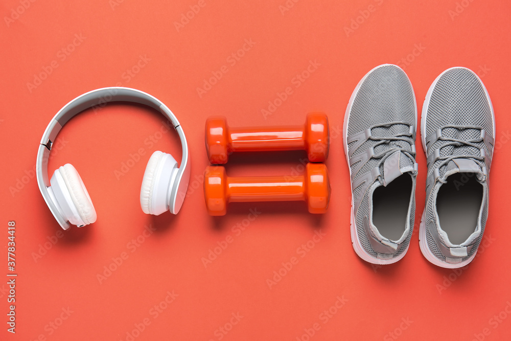 彩色背景运动鞋、哑铃和耳机