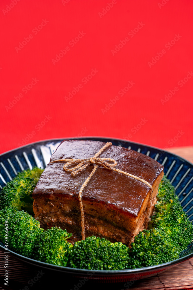 东坡肉（东坡肉）配绿色西兰花蔬菜，放在一个漂亮的蓝色盘子里，传统