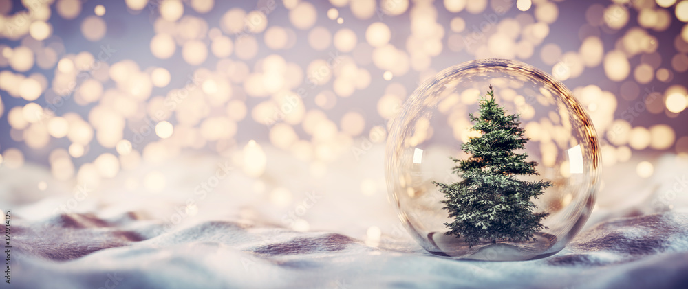 雪上玻璃球里的圣诞树。闪闪发光