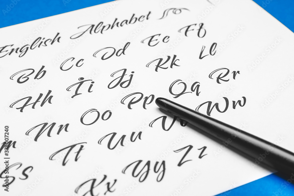 Pen and paper sheet with alphabet on color background, closeup
