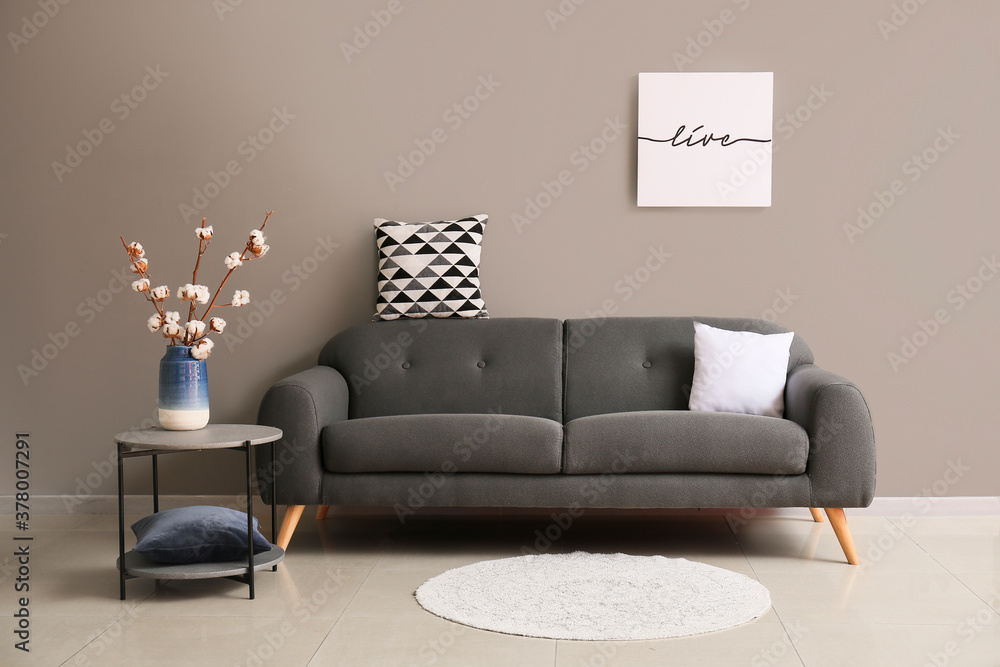 Comfortable sofa near grey wall in room