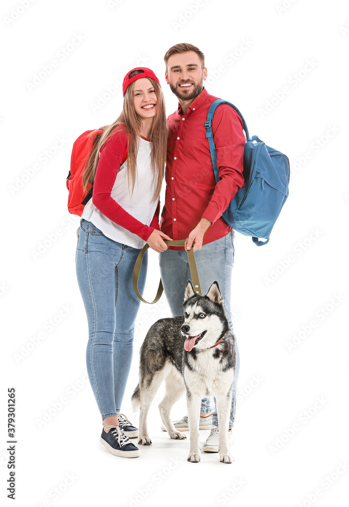 年轻夫妇与白色背景的可爱哈士奇狗