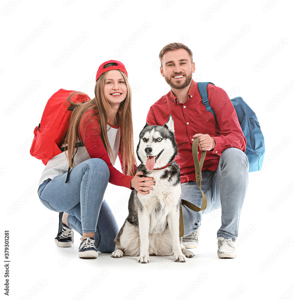 Young couple with cute Husky dog on white background