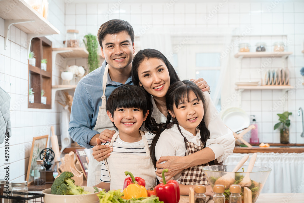 亚洲家庭在厨房里制作食物。快乐的家庭活动。