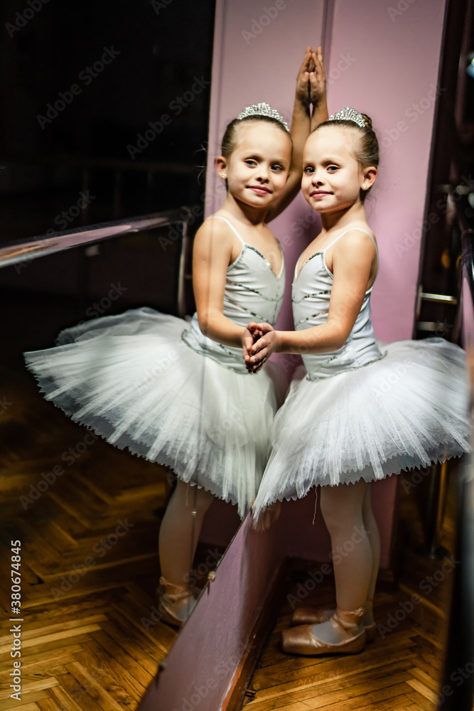 迷人的小芭蕾舞演员触摸镜子的肖像。年轻的芭蕾舞演员和反射镜。Portrai