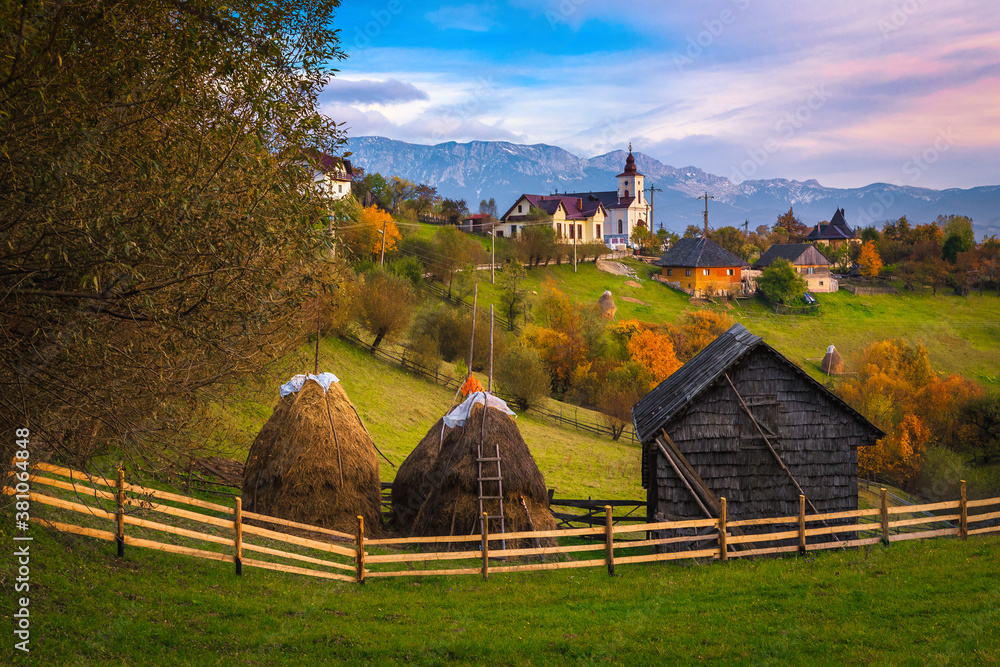 Autumn rural scenery with gardens and mountains in background, Romania