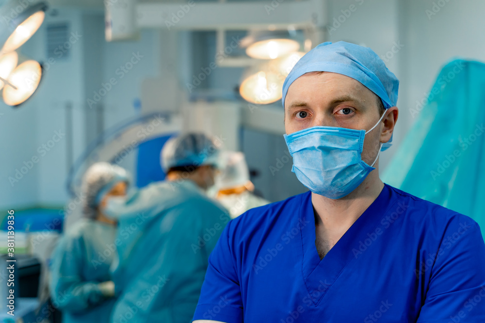 Male doctor or assistant is standing in an operation room. Medical background. Medic in scrubs.
