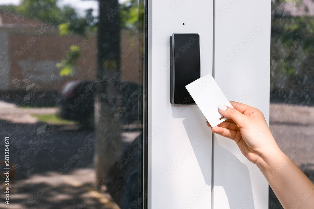 Woman using card to open door outdoors