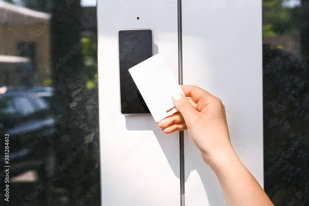 Woman using card to open door outdoors